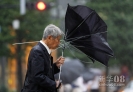  9月21日，在日本首都东京，一名路人在风雨中奋力握住手中的雨伞。 新华社/路透 