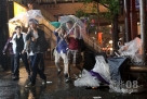 9月21日，在日本首都东京的涩谷站附近，行人走过被丢弃的破伞堆。新华社记者冯武勇摄