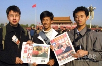 中国百姓关注入世 2001年11月11日，三位北京高校的学生拿着刊有中国入世消息的报纸在天安门广场合影留念。世界贸易组织第四届部长级会议于11月10日在卡塔尔首都多哈以全体协商一致的方式，审议并通过了中国加入世贸组织的决定。新华社记者高学余摄（数码传真照片） 
