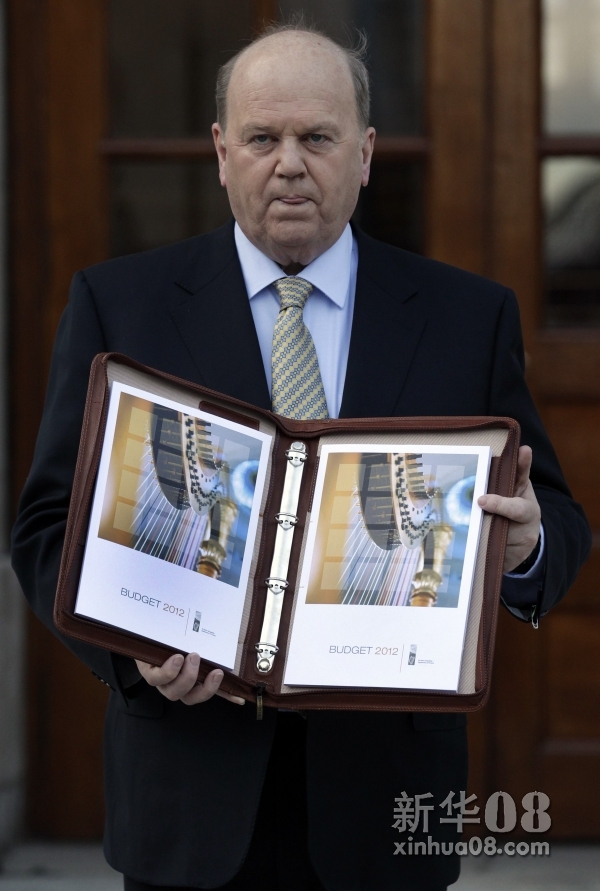 12月6日，在爱尔兰首都都柏林的政府大厦前，爱尔兰财政部长迈克尔·努南手持爱尔兰2012年财政预算案的副本。