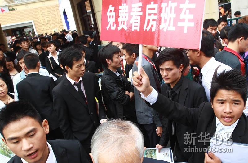 新华社照片，上海，2011年12月11日    “限购令”何去何从？——楼市“限购”一年间    众多楼盘销售人员在上海假日房展会上招揽看房的市民（6月7日摄）。    新华社记者 裴鑫 摄
