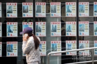 新华社照片，北京，2011年12月11日    “限购令”何去何从？——楼市“限购”一年间    12月11日，一名行人从北京万达CBD广场的一处房产中介中心走过。    新华社记者罗晓光摄  