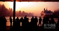 12月29日，游客在维多利亚湾畔欣赏日落美景。新华社照片，香港 新华社记者 陈晓伟 摄 2012年元旦和春节临近，来自世界各地的旅客涌进香港，掀起又一轮旅游购物热潮。截至12月21日，2011年抵港旅客人数已突破4000万人次。