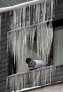 2月2日，在塞尔维亚西南部城市乌日策，一名男子从布满冰柱的窗口向外张望。新华社发（翟健岚编辑）