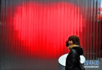 　　2月8日，一名游客在纽约时报广场触摸心形雕塑电子开关。日前，一个心形创意的电子发光雕塑在纽约时报广场向游客和市民开放，以迎接即将到来的情人节。这个心形创意电子雕塑由400个LED发光管组成，游客只要用手触摸电子开关，LED发光管就会闪现红色的心形。新华社记者王雷摄 