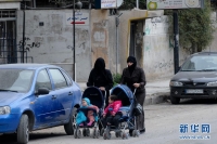 2月15日，在叙利亚大马士革东郊的哈尔斯特镇，两名妇女带着孩子出行。哈尔斯特镇距叙利亚首都大马士革以东约20公里，1月底叙利亚政府军曾在此与反对派武装发生激烈交火，并于1月30日重新控制了该地区。新华社记者覃海石摄