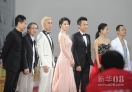 4月23日，刘亦菲（中）等走过红地毯。当晚，第二届北京国际电影节开幕式在国家会议中心举行。开幕式包括“嘉宾走红地毯”、“开幕式•光影流金”两部分内容。众多中外著名导演和明星亮相红地毯。新华社记者罗晓光摄