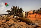 4月23日，在苏丹哈季利季油田，一些苏丹士兵站在一辆被炮火打坏的南苏丹坦克上庆祝胜利。新华社发（穆罕默德·巴比克尔 摄）