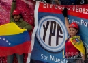 4月27日，阿根廷民众举着支持将该国第一大石油企业雷普索尔－YPF公司国有化的标语参加集会。新华社发（马丁·萨巴拉摄）