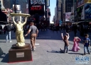 4月19日，几名儿童在美国纽约时报广场的《女娲补天》雕塑旁做出模仿动作。当日，来自中国的联合国首任环保艺术大师袁熙坤的雕塑作品《女娲补天》亮相纽约时报广场。受联合国环境规划署“补天行动”项目启发与邀请，袁熙坤运用中国神话中的女娲形象，以保护臭氧层为主题创作雕塑作品，警示全球环境保护的紧迫性并呼吁国际间在减缓气候变化中合作。新华社发