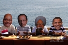 6月17日，在墨西哥海滨城市洛斯卡沃斯，人们戴着南非总统祖马、法国总统奥朗德、印度总理辛格和美国总统奥巴马（从左至右）的面具坐在海边。新华社/路透