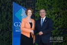 6月18日，在墨西哥洛斯卡沃斯的二十国集团领导人峰会会场，墨西哥总统卡尔德龙欢迎澳大利亚总理吉拉德。新华社发（戴维 摄）