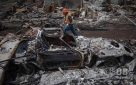 7月2日，在美国科罗拉多州科罗拉多斯普林斯，一名工人走过焚毁的汽车残骸。新华社/路透