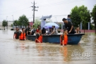 7月13日，解放军某部官兵在武汉市黄陂区百秀街用冲锋舟运送被困群众。新华社记者郝同前摄