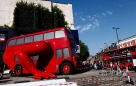这是2012年7月22日，在英国伦敦的捷克奥运代表团总部外，由捷克艺术家根据英国传统红色双层巴士改造的“会做俯卧撑的大巴机器人”展出。而在这件艺术品旁正好停靠着两辆传统红色双层巴士。新华社/路透（刘昀编辑）