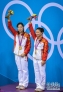 7月29日，吴敏霞（左）、何姿在颁奖仪式上庆祝。当日，在伦敦奥运会跳水女子双人3米板决赛中，中国选手吴敏霞/何姿以346.20分的成绩夺冠。新华社记者刘大伟摄 