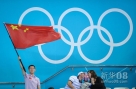 7月30日，在跳水赛场，一名中国观众挥舞五星红旗在为中国选手加油，他身旁的英国观众在交流时也流露出喜悦之情。当日，在伦敦奥运会男子双人10米跳台跳水决赛中，中国组合曹缘/张雁全以486.78分的总成绩夺冠，英国组合戴利/沃特菲尔德以454.65分的总成绩获得第四名。 新华社记者刘大伟摄