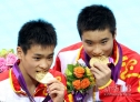 7月30日，曹缘和张雁全（左）在颁奖仪式后咬金牌。当日，在伦敦奥运会男子双人10米跳台跳水决赛中，中国组合曹缘/张雁全以486.78分的总成绩夺冠。新华社记者凡军摄 