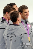 7月31日，美国队队员菲尔普斯（右一）在颁奖仪式露出笑容。当日，在伦敦奥运会游泳比赛男子4x200米自由泳接力决赛中，美国队以6分59秒70的成绩夺冠，这是菲尔普斯在本届奥运会上获得的第一枚金牌。新华社记者刘大伟摄