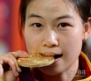 7月28日，易思玲在颁奖仪式上咬金牌。当日，在第30届夏季奥林匹克运动会女子10米气步枪决赛中，中国选手易思玲以502.9环的总成绩夺冠，这是本届奥运会的首枚金牌。新华社记者戚恒摄