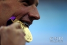  7月28日，美国选手罗切特在颁奖仪式上咬金牌。当日，在伦敦奥运会男子400米个人混合泳决赛中，美国选手罗切特以4分05秒18的成绩夺得冠军。新华社记者费茂华摄 