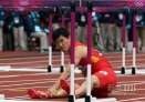 8月7日，中国选手刘翔在比赛中摔倒后坐在赛道上。当日，刘翔在伦敦奥运会田径男子110米栏预赛中摔倒，无缘晋级。新华社记者王丽莉摄 