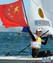 8月6日，徐莉佳手持国旗庆祝。当日，在韦茅斯－波特兰港举行的伦敦奥运会帆船女子单人艇－激光雷迪尔级奖牌轮比赛中，中国选手徐莉佳以35分的成绩夺冠。新华社记者公磊摄 