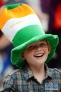 8月6日，一名头戴爱尔兰国旗颜色帽子的儿童开心地笑着。当日，一群用爱尔兰绿、白、橙国旗颜色进行装饰，开心挥舞着爱尔兰国旗的观众，盛装前来伦敦国际展览中心观看伦敦奥运会拳击比赛。新华社记者杨宗友摄