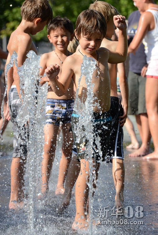 8月19日，德国柏林的儿童在街头喷泉中嬉戏。当日，德国首都柏林最高气温达到35.2摄氏度，是1948年以来的同期最高温。德国西部其它地区也出现了38摄氏度以上的高温，成为今年以来德国最热的一天。（记者马宁 摄）