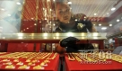 宁夏银川市一家商场工作人员在为顾客拿取黄金饰品。