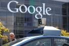 9月25日，在美国加利福尼亚州芒廷维尤的谷歌总部，路人查看一辆谷歌自动驾驶汽车顶部的摄像头。新华社/法新  
