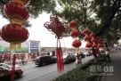 9月24日，工人在北京市东城区银街安装红灯笼和中国结。 中秋和国庆两节临近，北京一些路段的国庆花坛和灯笼等装饰物已摆放完成，为京城增添了浓浓的节日气氛。新华社发（罗伟 摄） 