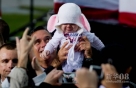 10月8日，在美国弗吉尼亚州纽波特纽斯，美国共和党总统候选人米特·罗姆尼在一场竞选活动中抱起一名婴儿。新华社/法新