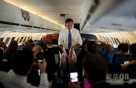 10月8日，在美国弗吉尼亚州谢南多厄谷地区机场登机的美国共和党总统候选人米特·罗姆尼在飞机上拿着快餐袋。新华社/法新  