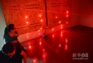 10月10日，游戏者在“生化密所”游戏中准备闯过布有红外线装置的密室。
