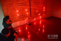10月10日，游戏者在“生化密所”游戏中准备闯过布有红外线装置的密室。