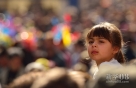 10月21日，在意大利中部山城佩鲁贾市中心，一名嘴边挂满巧克力汁的小姑娘骑在大人肩头。新华社记者王庆钦摄 