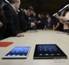10月23日，与会者在美国圣何塞举行的苹果新品发布会上比较iPad mini和iPad。新华社发