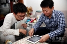 10月21日，刘杨（右）在帮助自己的大学同学分析理财产品。新华社记者 郑焕松 摄 