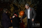 10月31日晚，加拿大总理斯蒂芬·哈珀在渥太华总理官邸和打扮得千奇百怪、前来讨糖果的孩子们合影，共同欢度万圣节前夜。新华社发（詹姆斯·派克摄） 