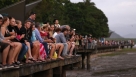 11月14日，在澳大利亚城市凯恩斯，游客们聚集在岸边等待观看日全食。这次日全食，全食带从澳大利亚东北部开始，向东进入南太平洋，在到达南美洲大陆前结束。最长见食时间地点位于新西兰以东的南太平洋中，可见时间为4分02秒。新华社/路透