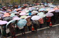 11月25日，南京林业大学考点的考生在考场外冒雨等待进入考场。新华社发（刘建华 摄）