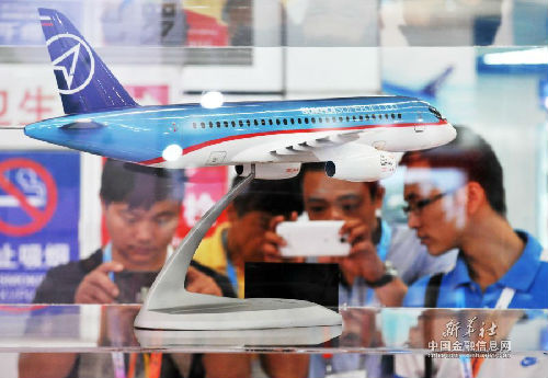 6月30日，在中俄博览会上，参会人员拍摄俄罗斯馆的飞机模型。新华社记者王建威摄  