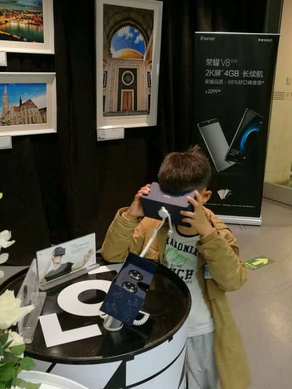 图为小观众在新华社“一带一路全球行”荣耀V8影像专区内体验VR设备。