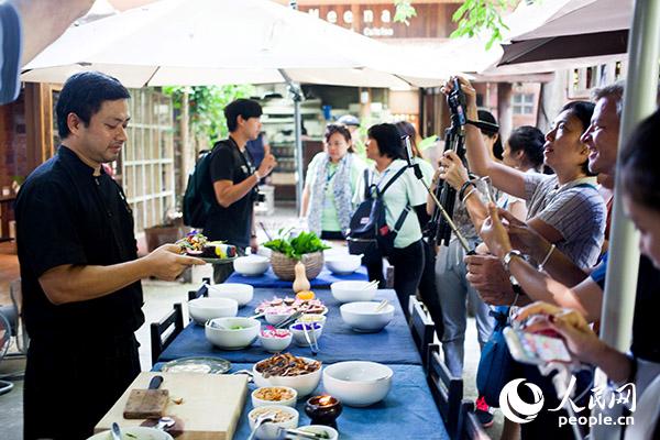 外国游客在泰国清迈一家餐厅体验烹制当地美食。