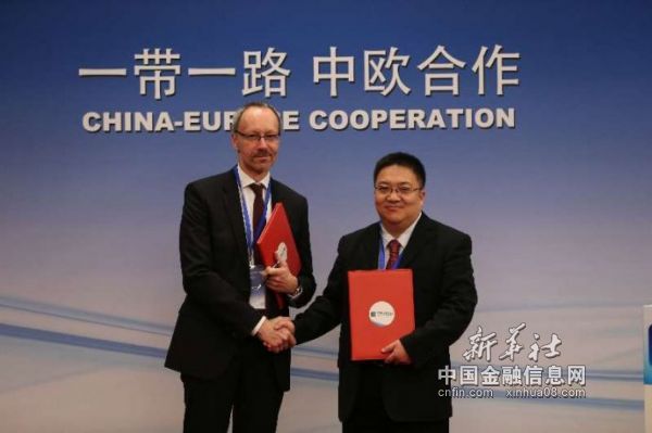 图为中经社副总裁匡乐成（右）与德新社经济信息社Martin Kalverkamp (左）交换合作备忘录文本（新华社记者 罗欢欢摄）