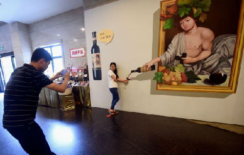 资料图片：游客在烟台张裕酒文化博物馆立体画作前拍照留念。（新华社）