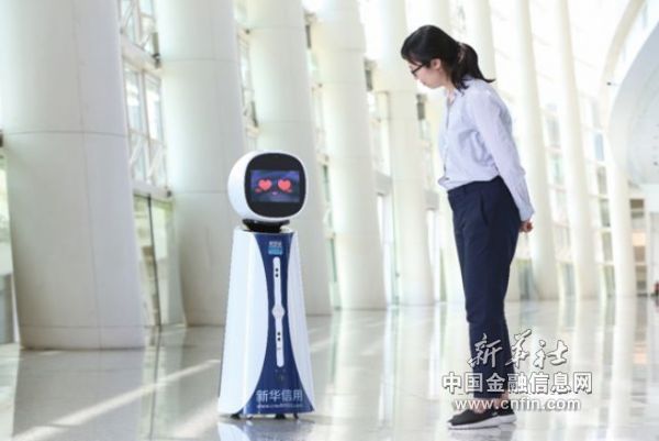 在2018年中国城市信用建设高峰论坛上，新华信用机器人“小i”在为参会人员提供服务。王吉如摄