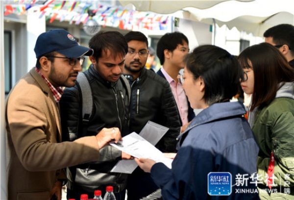 4↑10月13日，几名北京理工大学的留学生在创业企业创新人才招聘区咨询招聘信息。新华社记者罗晓光摄