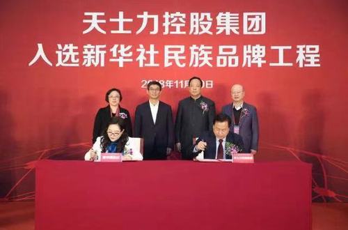 新华社新闻信息中心副主任胡玉霞(左）与天士力控股集团副总裁吴丹勇代表双方签署合作协议